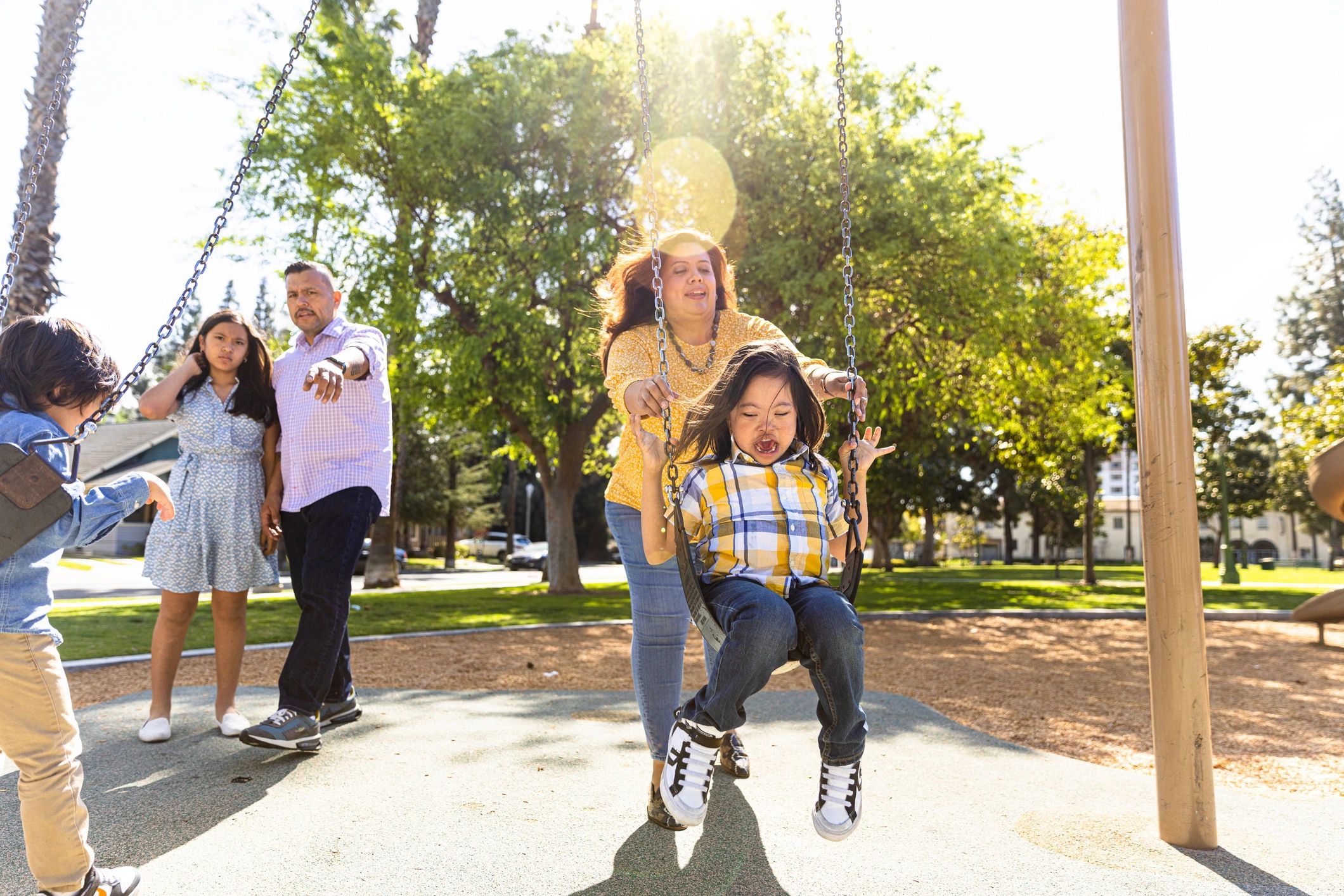Family at a park with a child on a swing