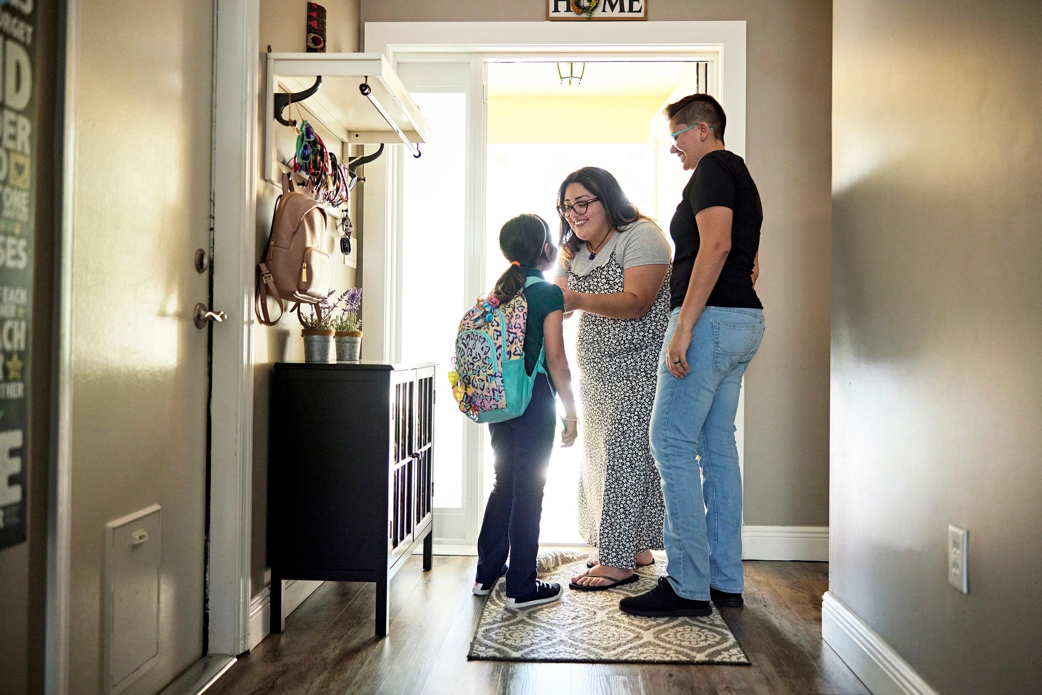 Parent helping a child get ready with a backpack