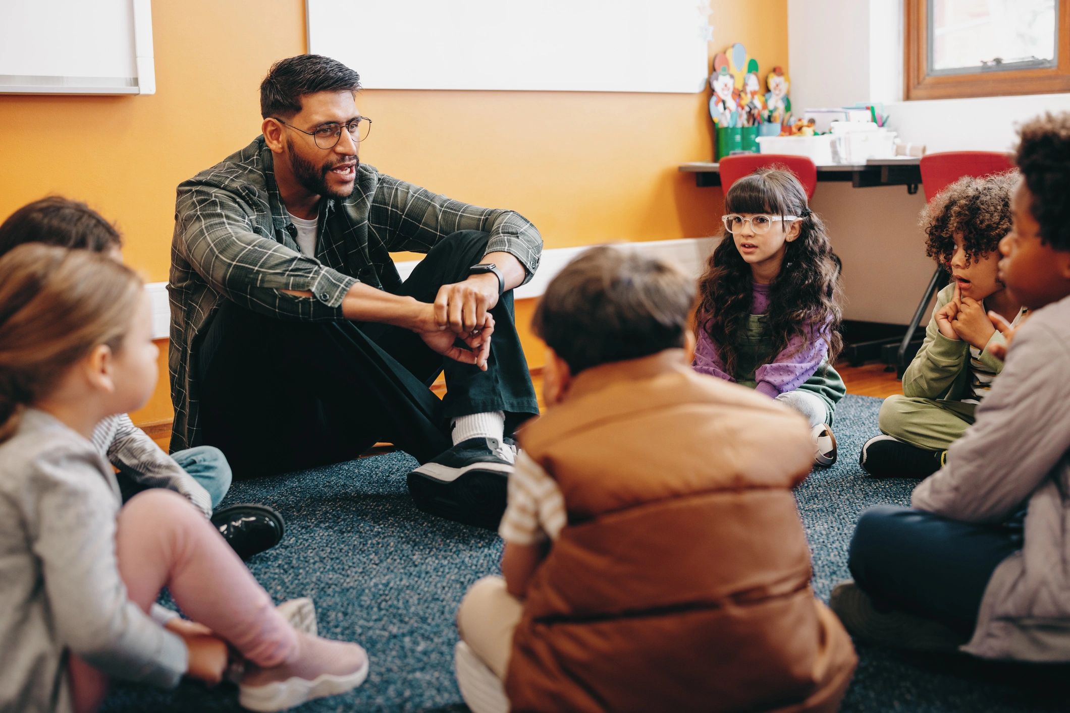 Teacher sitting with children in a classroom circle