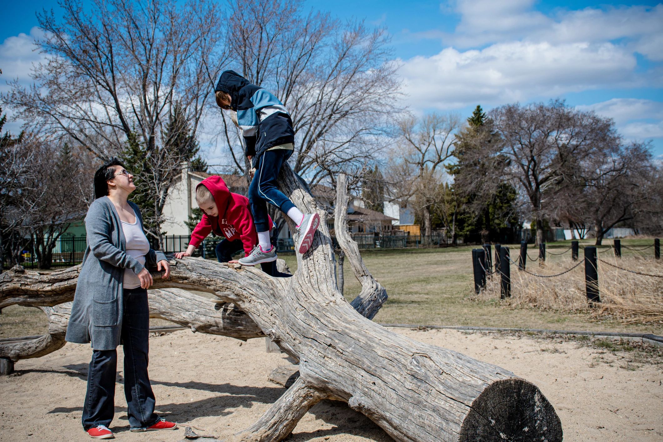 Parent and children enjoying outdoor play on a sunny day