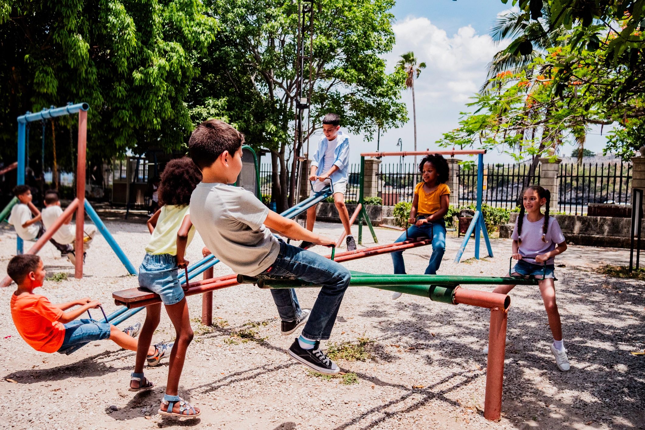Children playing outdoors on a playground seesaw