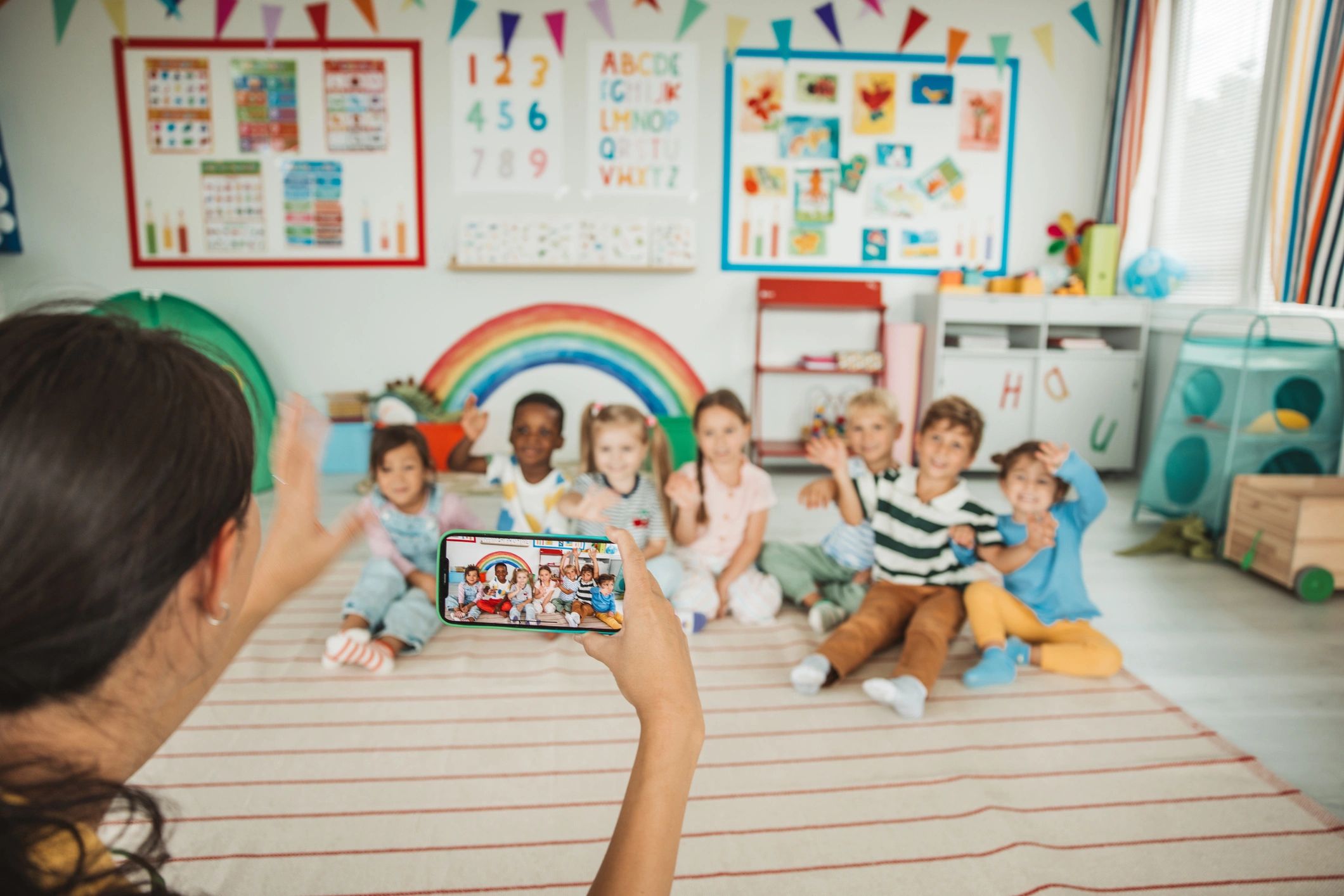 Teacher capturing a photo of students during playtime